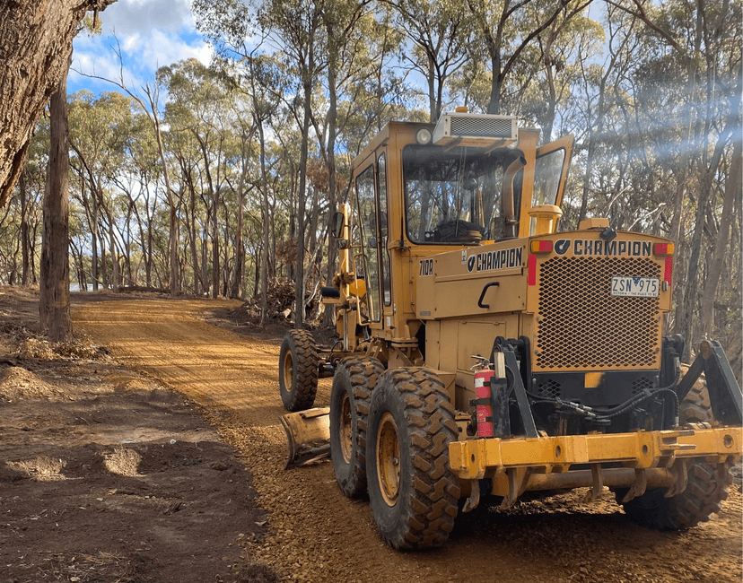 Champion motor grader on graded road - Anderson & Sons earthmoving equipment in Victoria